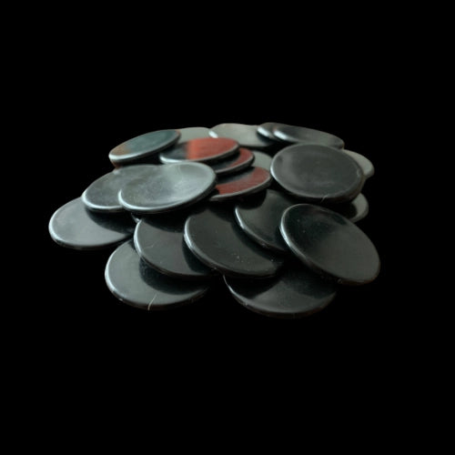 Stack of black round Coins on a black background for the card game, Thicker Than Blood